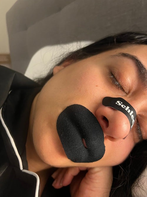 Person sleeping comfortably wearing Schleepi mouth tape with a slit designed to support nasal breathing during sleep.